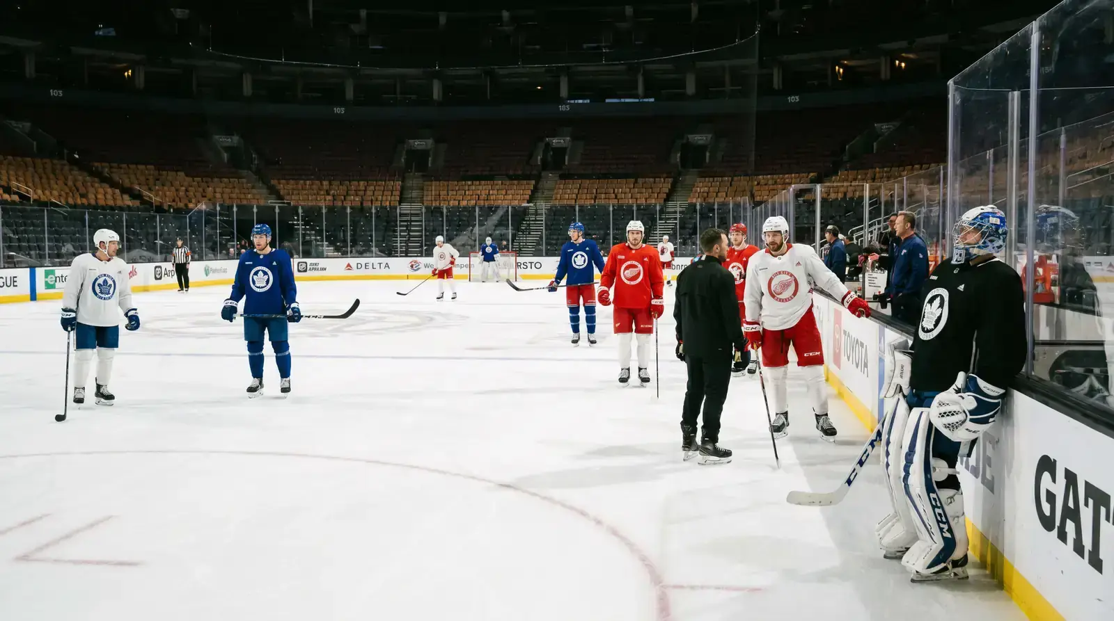 NHL players and goaltender on the ice during a morning skate session