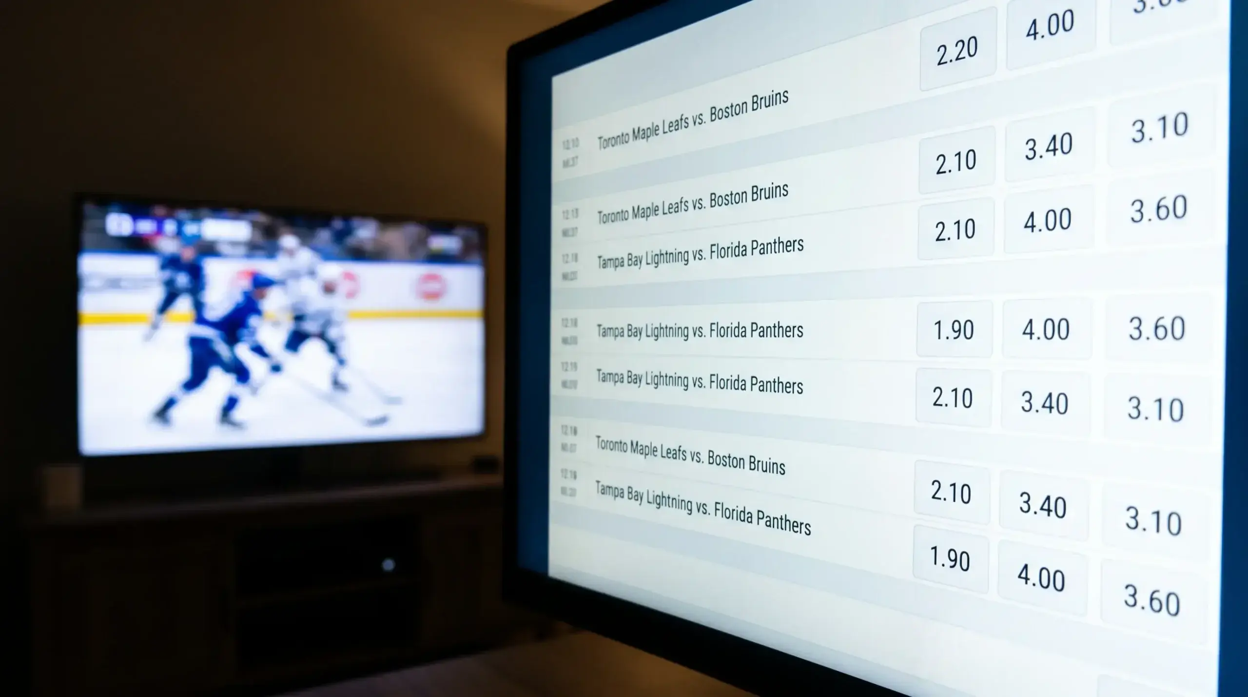Close-up of decimal odds on a betting screen with a hockey game in the background