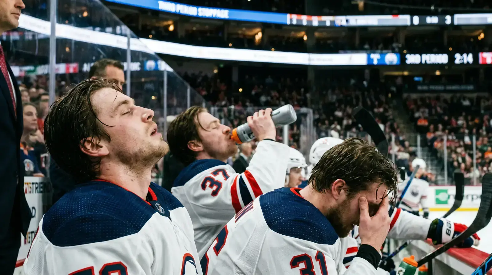 Exhausted hockey players on the bench during a late third-period stoppage
