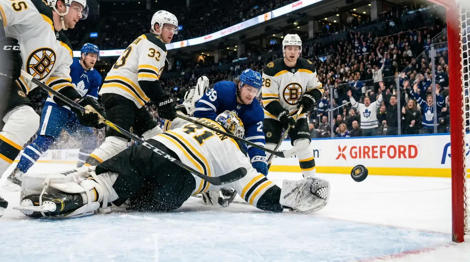 Intense third-period NHL action with players racing toward the net under bright arena lights